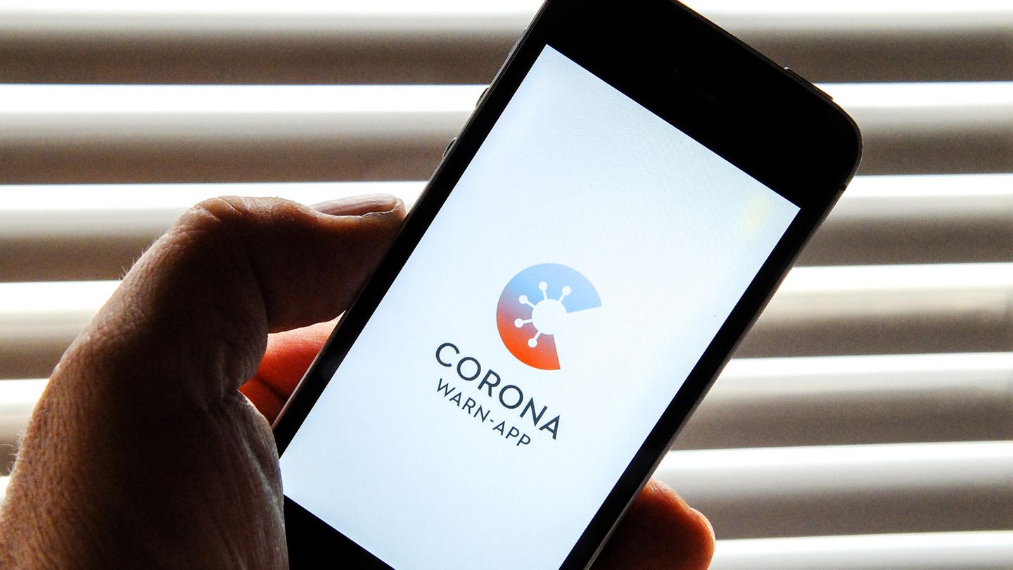 Auf dem Bildschirm eines Smartphones ist der Startschirm einer Corona Warn-App abgebildet