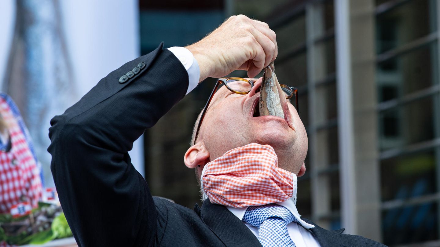 Mann isst Hering im Ganzen