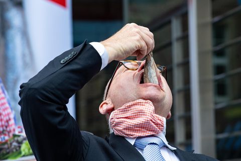 Mann isst Hering im Ganzen