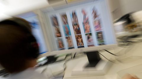 Ermittler sitzt vor einem Monitor mit kinderpornografischen Inhalten