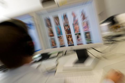 Ermittler sitzt vor einem Monitor mit kinderpornografischen Inhalten