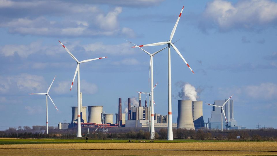 Selbst vor dem riesigen Braunkohlekraftwerk Neurath im Rheinland drehen sich inzwischen Windräder
