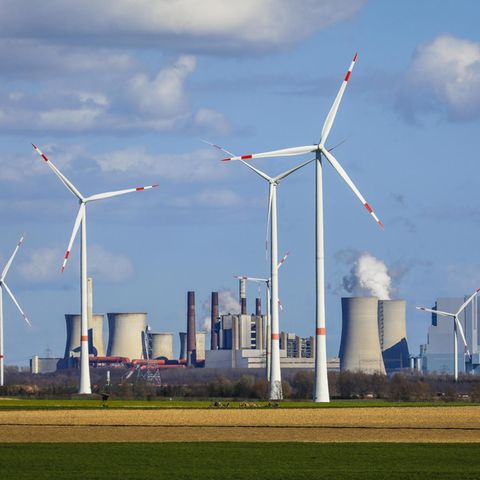 Selbst vor dem riesigen Braunkohlekraftwerk Neurath im Rheinland drehen sich inzwischen Windräder