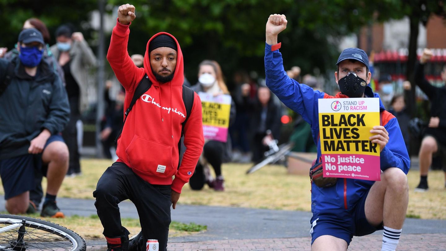 Ein weißer und ein schwarzer Mann knien bei "Black Lives Matter"-Protesten