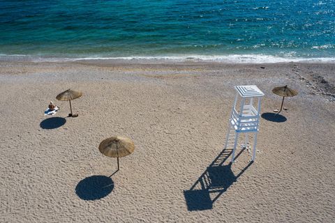 Griechenland, Athen: Eine Frau sitzt an einem Strand mit Blauer Flagge südlich von Athen