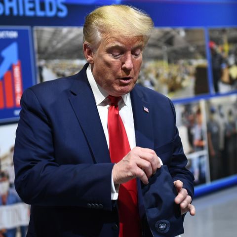 Donald Trump hantiert mit einer eingepackten Maske