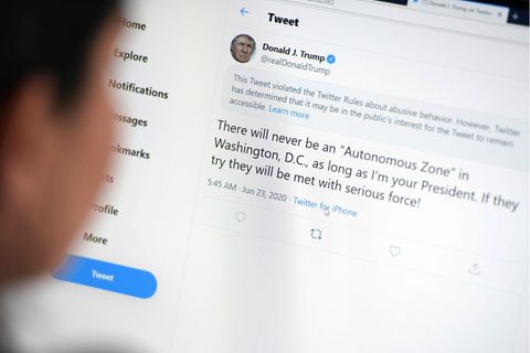 Nutzerin liest gesperrten Tweet von Donald Trump am Bildschirm