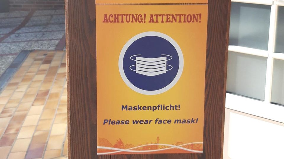 Ein Schild zeigt die Abbildung einer Maske und Hinweise zu den Hygienemaßnahmen des Heide Parks.