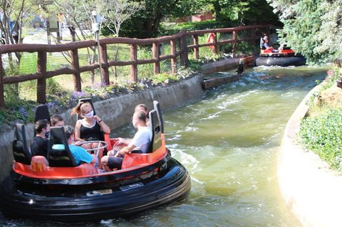Ein "Mountain Rafting"-Boot schwimmt durch den Kanal. Die Insassen tragen Mund-Nasen-Schutzmasken.