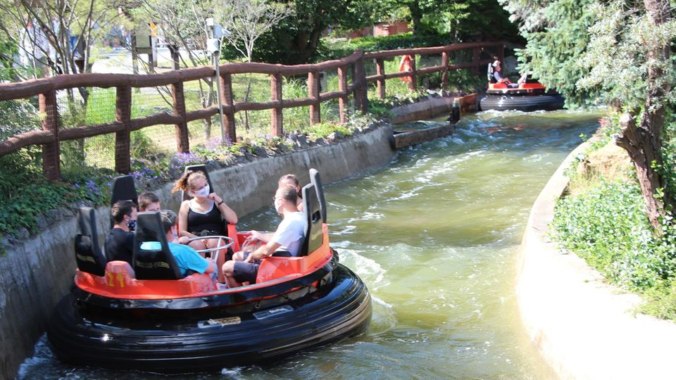 Ein "Mountain Rafting"-Boot schwimmt durch den Kanal. Die Insassen tragen Mund-Nasen-Schutzmasken.