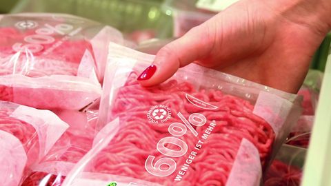 Eine Frauenhand greift Hackfleisch in einem Supermarkt (Symbolbild)