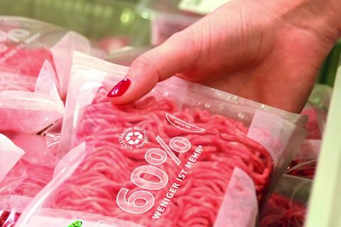 Eine Frauenhand greift Hackfleisch in einem Supermarkt (Symbolbild)