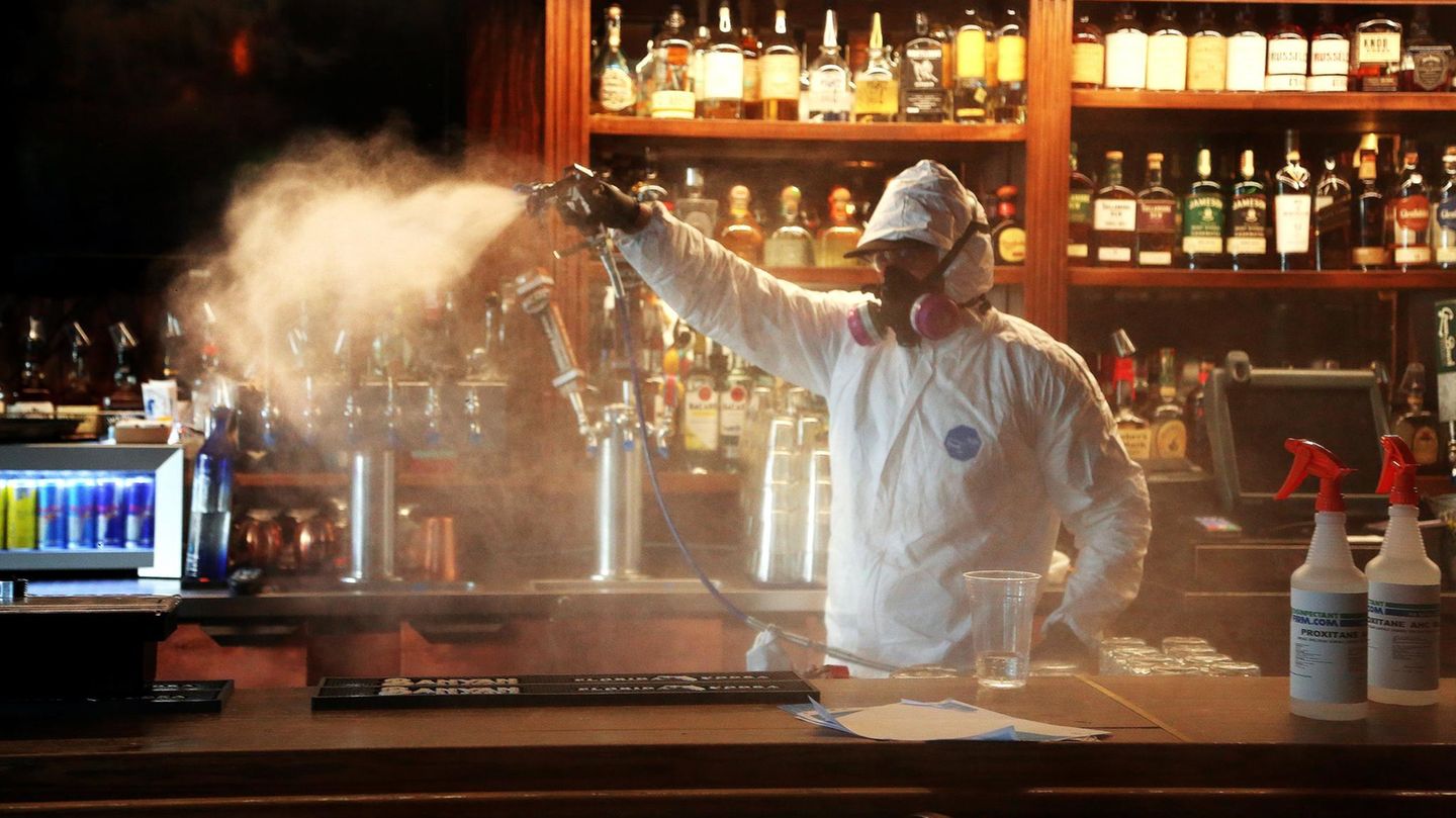 USA, St. Petersburg: Miteigentümer einer Desinfektionsfirma desinfiziert den Tresen in einem Gasthaus. Die Corona-Krise in den USA verschärft sich erneut dramatisch. 