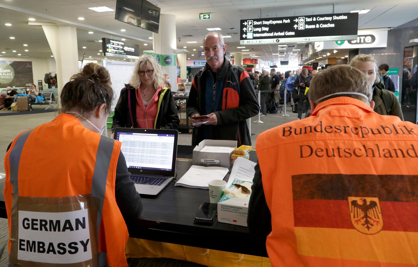 Am Flughafen Christchurch in Neuseeland warten Touristen am Terminalauf die Kontrolle durch Mitarbeiter der deutschen Botschaft, bevor sie für einen Flug nach Deutschland eingecheckt werden.