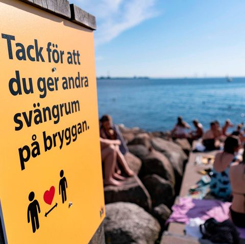 Ein Schild weist an einer vollen Badestelle in Malmö darauf hin, Abstand zu halten