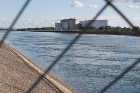 Blick durch ein Sicherheitszaun auf das Atomkraftwerk Fessenheim in Ostfrankreich