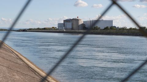Blick durch ein Sicherheitszaun auf das Atomkraftwerk Fessenheim in Ostfrankreich
