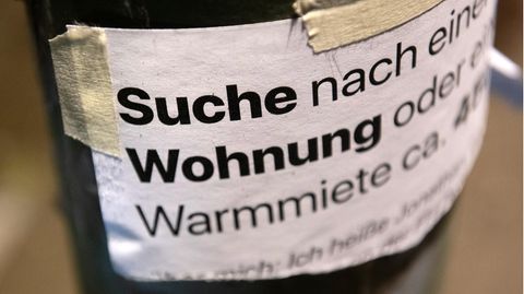 An einer Laterne klebt ein Zettel mit einem Wohnungsgesuch