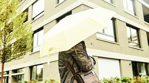 Jasmin mit Regenschirm vor einem Wohnblock
