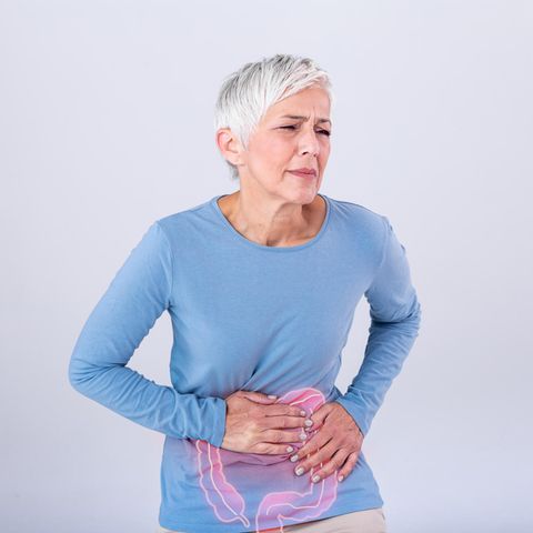 Eine Frau hält sich vor Schmerzen den Bauch