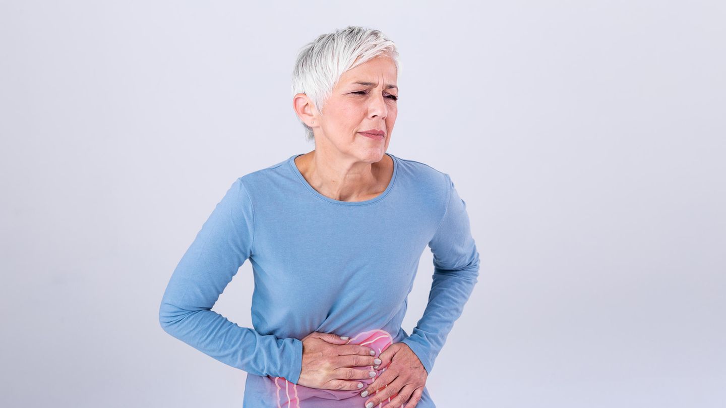 Eine Frau hält sich vor Schmerzen den Bauch