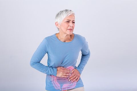 Eine Frau hält sich vor Schmerzen den Bauch