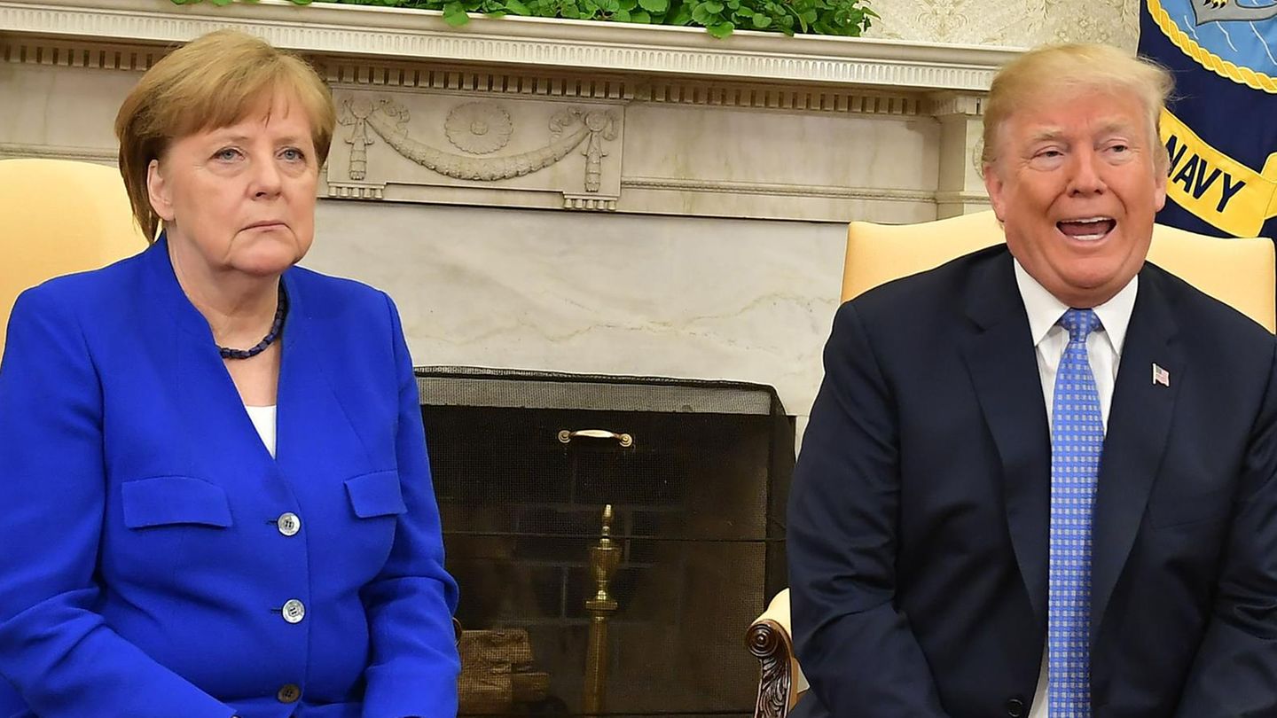 Donald Trump und Angela Merkel sitzen nebeneinander vor einem Kamin