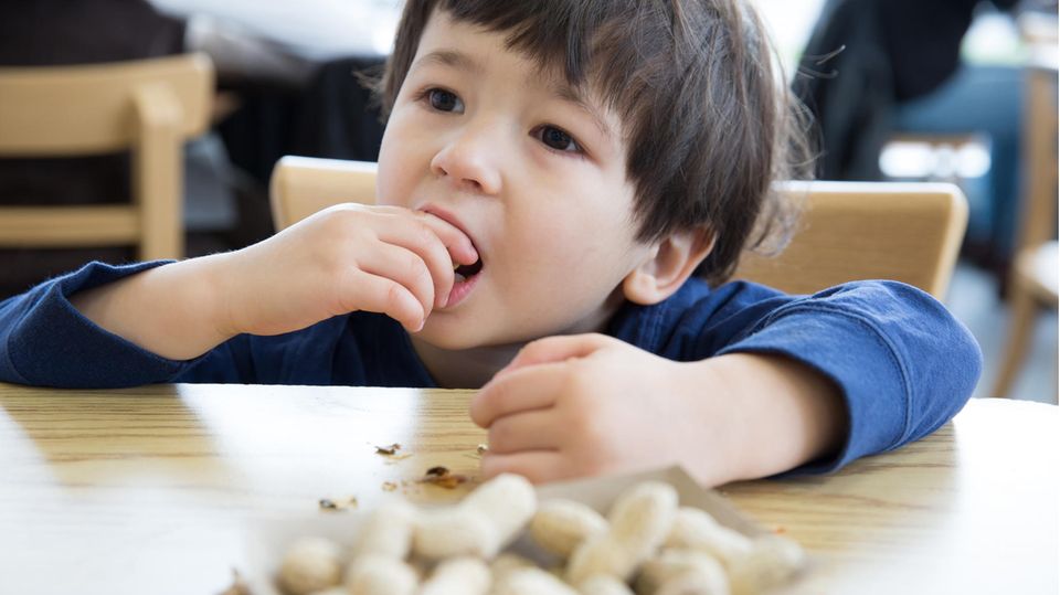 Ein Junge isst Erdnüsse
