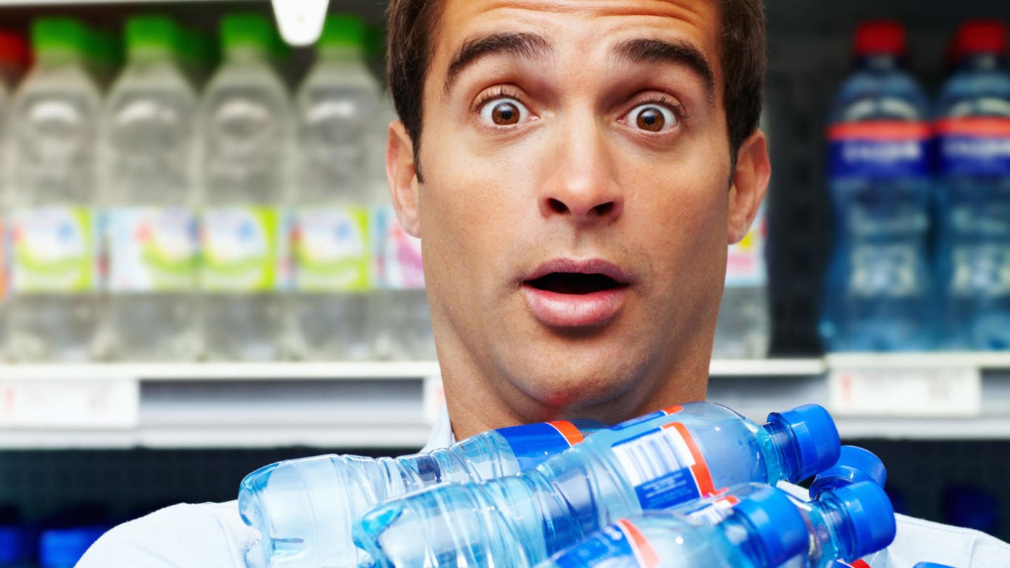 Mann hält Wasserflaschen im Arm