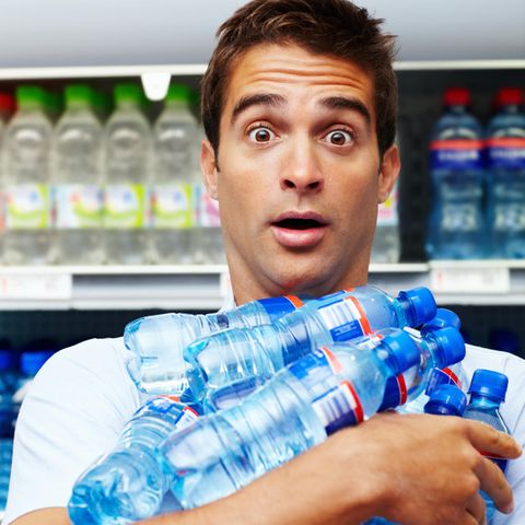 Mann hält Wasserflaschen im Arm