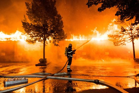 Hamburg: Ein Feuerwehrmann löscht einen Brand in einem Geschäft für Tierfutter