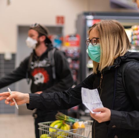 Kunden gehen in einem Supermarkt einkaufen und tragen dabei Mundschutz