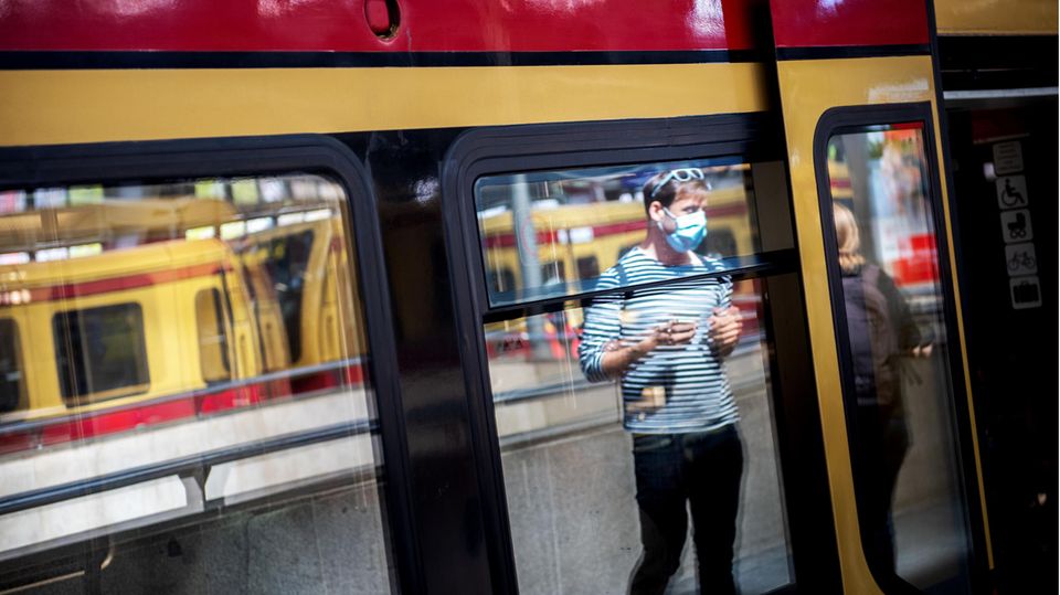 Ein Mann mit Mundschutz betritt am Ostbahnhof in Berlin eine S-Bahn