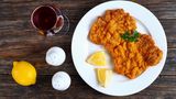Rezept für Schnitzel “Münchner Art” mit Erdäpfel-Specksalat und Gurke      Zutaten für 2 Personen:15g süßer Senf25g Meerrettich500g festkochende Kartoffeln1 Rinderbrühwürfel1 Zwiebel50g gewürfelten Speck1 Gurke4 Schweinerückensteaks (Minutensteaks)etwas Kümmel10g frische Petersilie10g frischer Dill  Zubereitung:      1. Kartoffeln waschen, in einen Kochtopf mit ausreichend gesalzenem Wasser und Kümmel geben. Zum Kochen bringen, zugedeckt ca. 15-20 Minuten leicht köchelnd bissfest garen. Tipp: Wenn man leicht durchstechen kann, sind sie durch. Wasser abgießen und etwas auskühlen lassen.  2. Inzwischen Gurke waschen, halbieren, Kerngehäuse mit einem Teelöffel ausschaben und den Rest in möglichst dünne Scheiben schneiden. Dill waschen, ohne harte Stiele fein hacken. Gurke in einer Schüssel mit Dill, Salz, Pfeffer und einer Prise Zucker vermengen.  3. Meerrettich schälen, fein raspeln. Hälfte mit Senf vermengen. Je nach Geschmack mehr Meerrettich zugeben. Fleisch sollte ca. fingerdick sein. Wenn nicht, mit einer Pfanne zwischen Frischhaltefolie dünner klopfen. ¼ Brühwürfel in 150 ml heißem Wasser auflösen.  4. Wasser der Kartoffeln abgießen und diese kurz abkühlen lassen. Zwiebel schälen, eine Hälfte fein würfeln. Petersilie waschen, fein hacken. Ausgekühlte Kartoffeln mit einem Messer pellen und in ca. 1 cm dicke Scheiben schneiden. Kartoffeln mit Zwiebeln in eine Schüssel geben.  5. Speck ohne Fett in der großen Pfanne knusprig anbraten und zu den Kartoffeln geben. Kartoffeln mit Hälfte der Brühe, 3 EL Essig, 2 EL Öl, Salz und Pfeffer abschmecken. Dann unterheben und je nach Geschmack mehr Brühe untermengen.  6. Zum Schluss Pfanne auswischen, mit 2 EL Öl erneut erhitzen und Fleisch ca. 2-3 Minuten goldbraun anbraten. Aus der Pfanne nehmen, mit Salz und Pfeffer würzen und Schnitzelsauce darauf verteilen. Mit Kartoffel- und Gurkensalat anrichten.