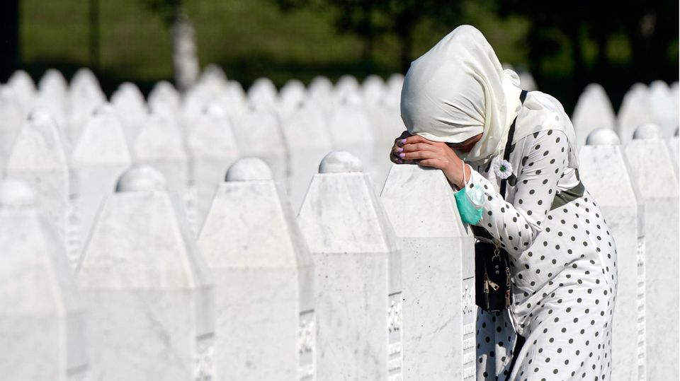 Eine Frau trauert auf dem Friedhof der Gedenkstätte Potocari in der Nähe von Srebrenica an einem Grab
