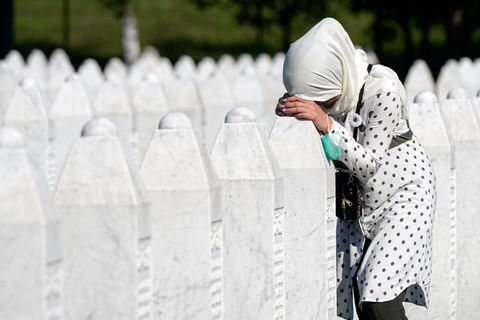 Eine Frau trauert auf dem Friedhof der Gedenkstätte Potocari in der Nähe von Srebrenica an einem Grab