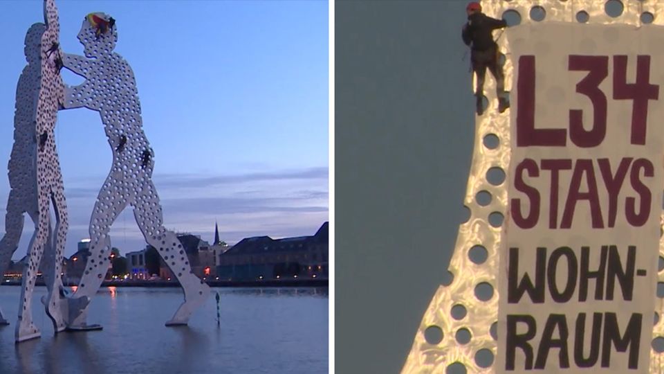 Molecule Man Berlin Aktivisten klettern auf dem Molecule Man in Berlin herum und bringen ein Transparent an