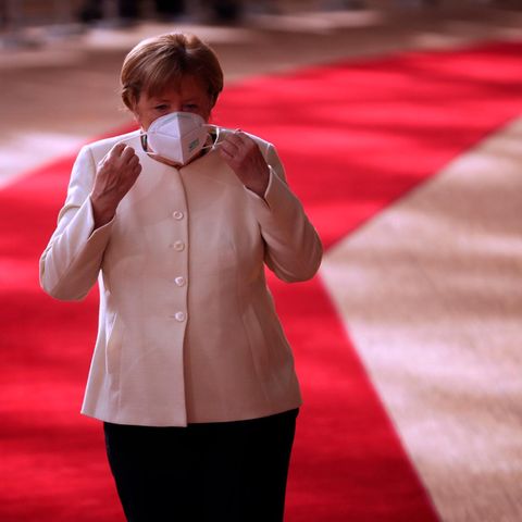 Angela Merkel setzt sich am Sonntag Morgen beim EU-Gipfel eine Maske auf.