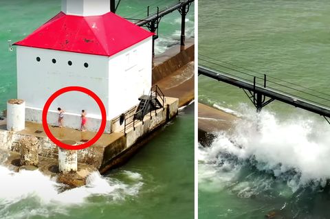Zwei Kinder stehen an einem weißen Leuchtturm mit rotem Dach. Wellen spülen über die Mole, an dessen Ende der Leuchtturm steht