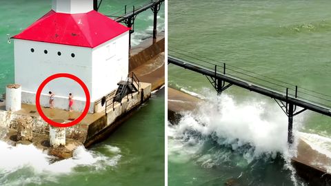 Zwei Kinder stehen an einem weißen Leuchtturm mit rotem Dach. Wellen spülen über die Mole, an dessen Ende der Leuchtturm steht