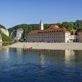 Kloster Weltenburg  Rund 110 Kilometer ist die Münchner Innenstadt vom Kloster Weltenburg entfernt. Das Kloster ist weniger bekannt als das Kloster Andechs, das ebenfalls ein beliebtes Ausflugsziel im Münchner Umland ist. Dafür ist das Kloster Weltenburg auch weniger überlaufen. Die Abtei St. Georg in Weltenburg ist eine aktive Benediktinische Abtei. Derzeit finden aufgrund der Corona-Pandemie keine Führungen statt. Auch das Besucherzentrum ist geschlossen. Ein Besuch lohnt sich dennoch. Denn auch das Kloster von außen und seine außergewöhnliche Lage - immer wieder wird das Kloster von der Donau geflutet - sind ein Besuch wert. Weitere Informationen zu Führungen finden Sie hier.