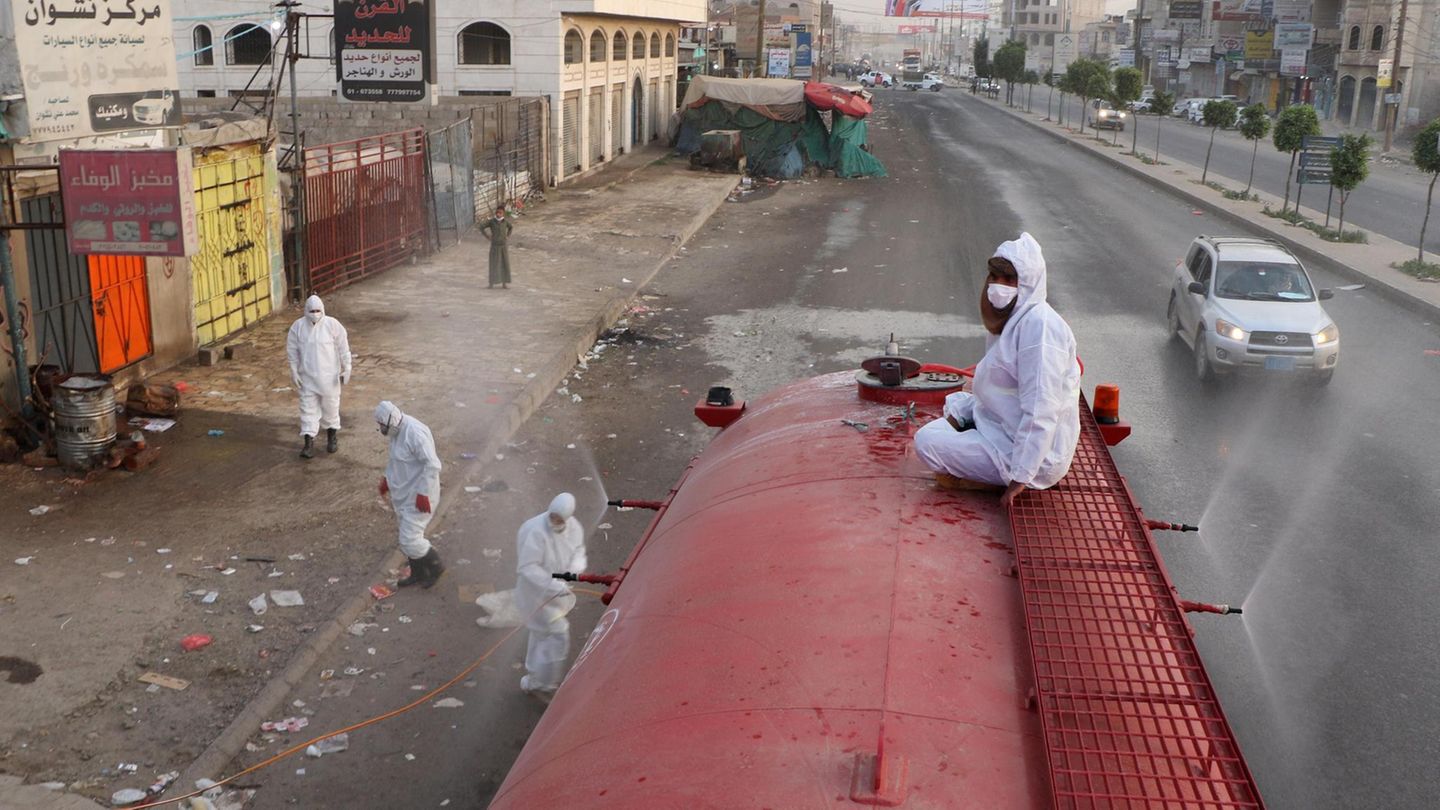 19.05.2020, Jemen, Sanaa: Arbeiter desinfizieren eine Straße, um die Ausbreitung des Coronavirus einzudämmen. Foto: Mohammed Mohammed/XinHua/dpa +++ dpa-Bildfunk +++ Jemen, Sanaa: Arbeiter desinfizieren eine Straße