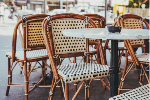 Stühle mit Tischen in einem Außenbereich eines Cafés