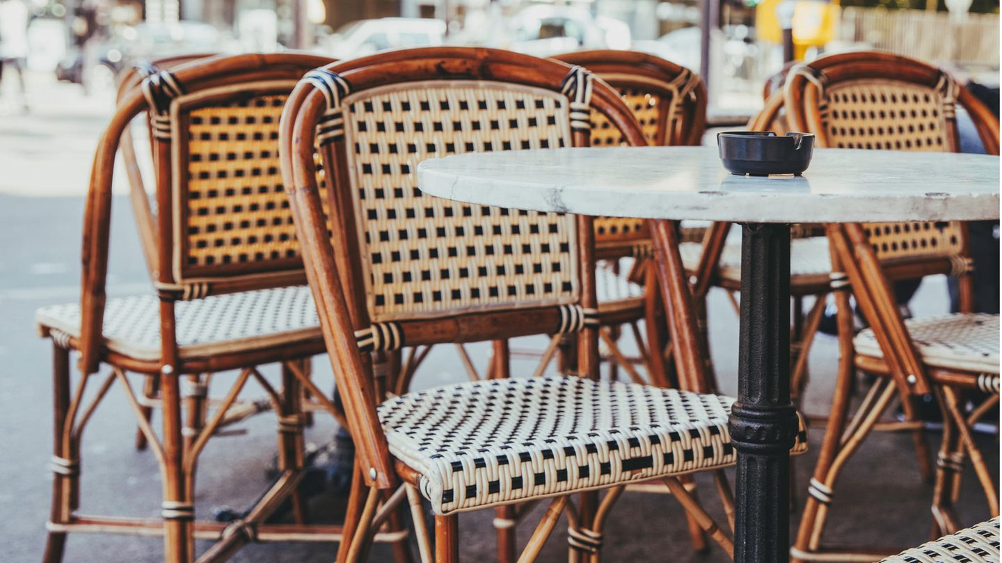 Stühle mit Tischen in einem Außenbereich eines Cafés