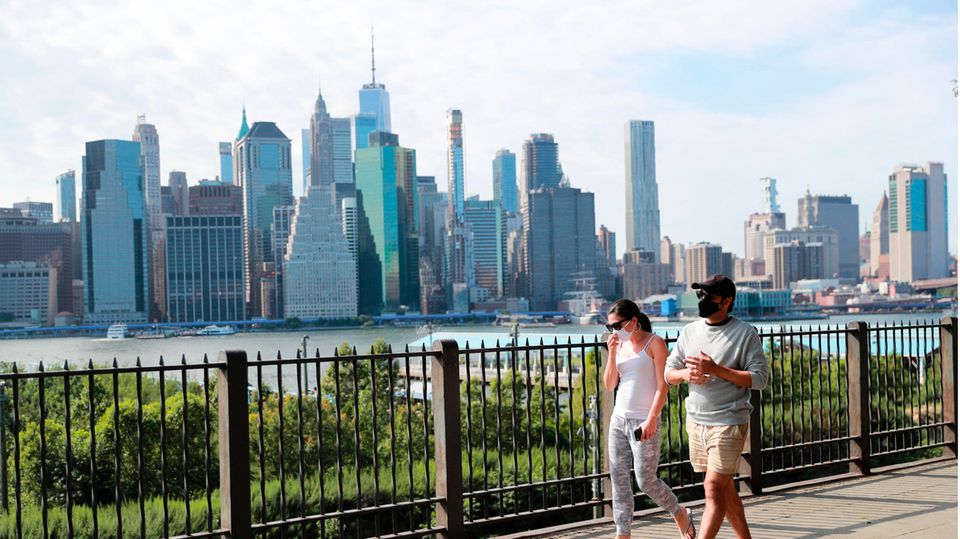 Passanten tragen Schutzmasken und gehen in einem Park im New Yorker Stadtteil Brooklyn spazieren