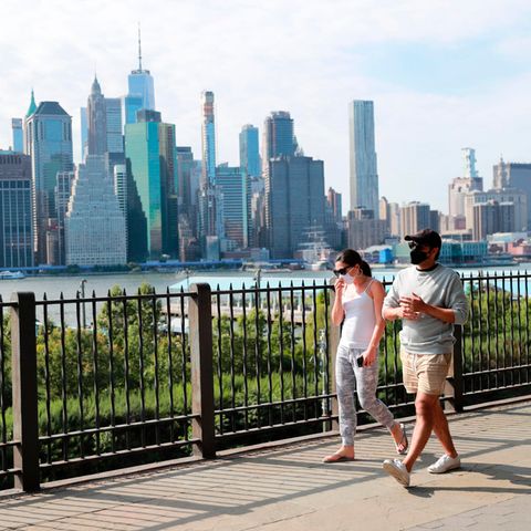 Passanten tragen Schutzmasken und gehen in einem Park im New Yorker Stadtteil Brooklyn spazieren