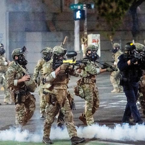 Bundespolizisten richten ihre Waffen auf Demonstranten