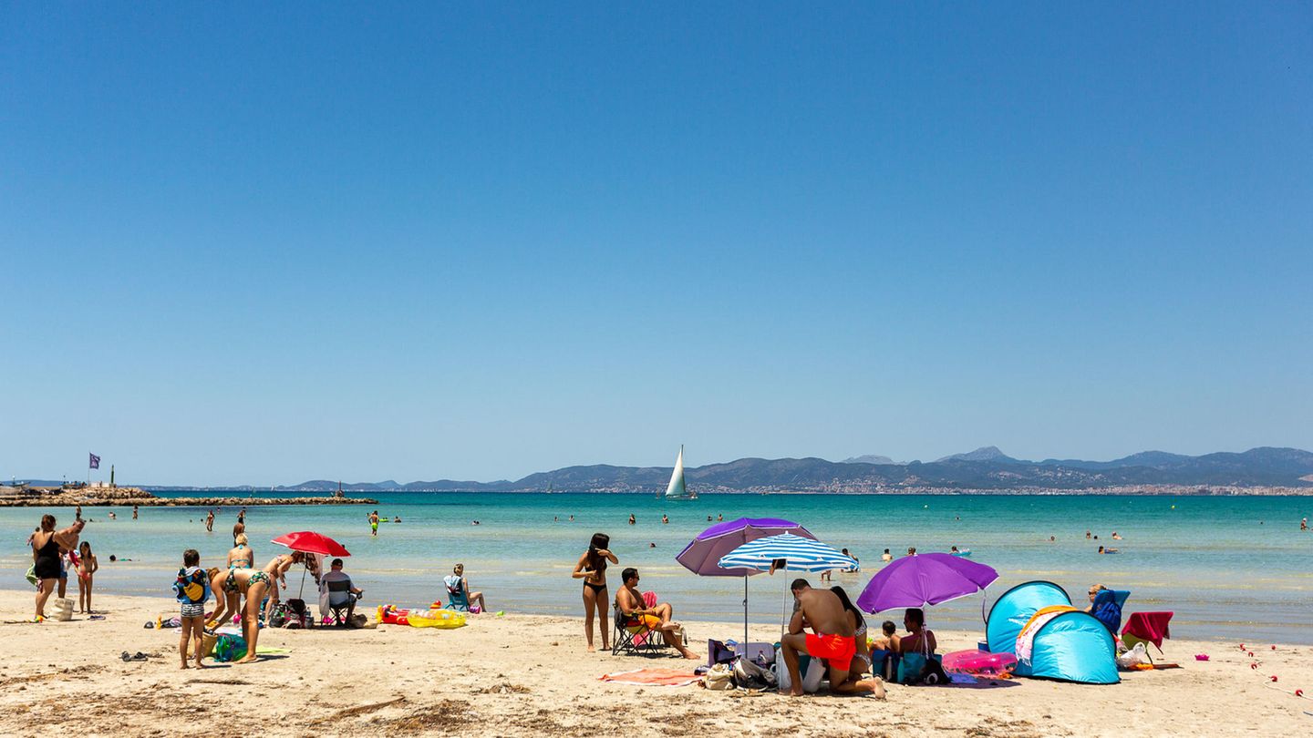 Urlauber sonnen sich an einem Strand auf Mallorca