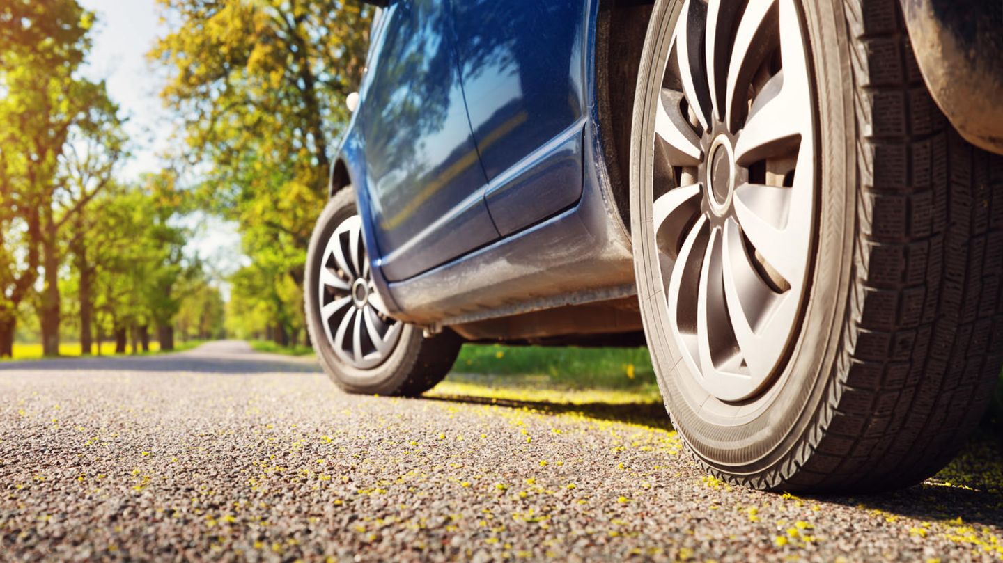 Ein blaues Auto auf einer Straße im Sommer