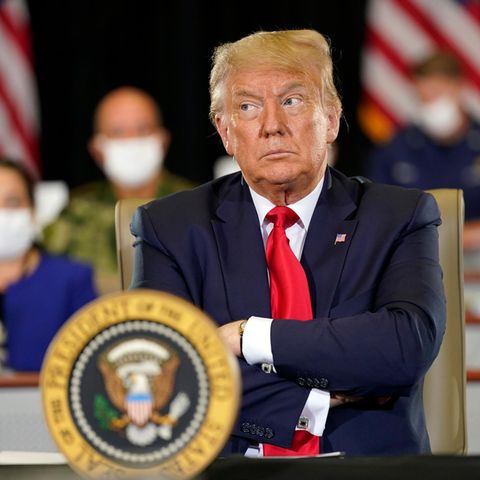 Donald Trump mit verschränkten Armen und zweifelndem Blick
